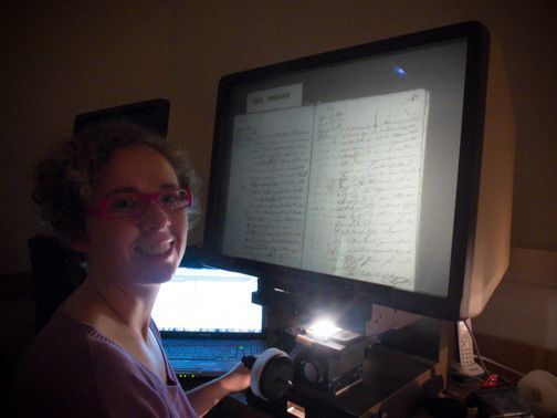 Mireia Nieto, genealogista profesional, consultando documento microfilmado